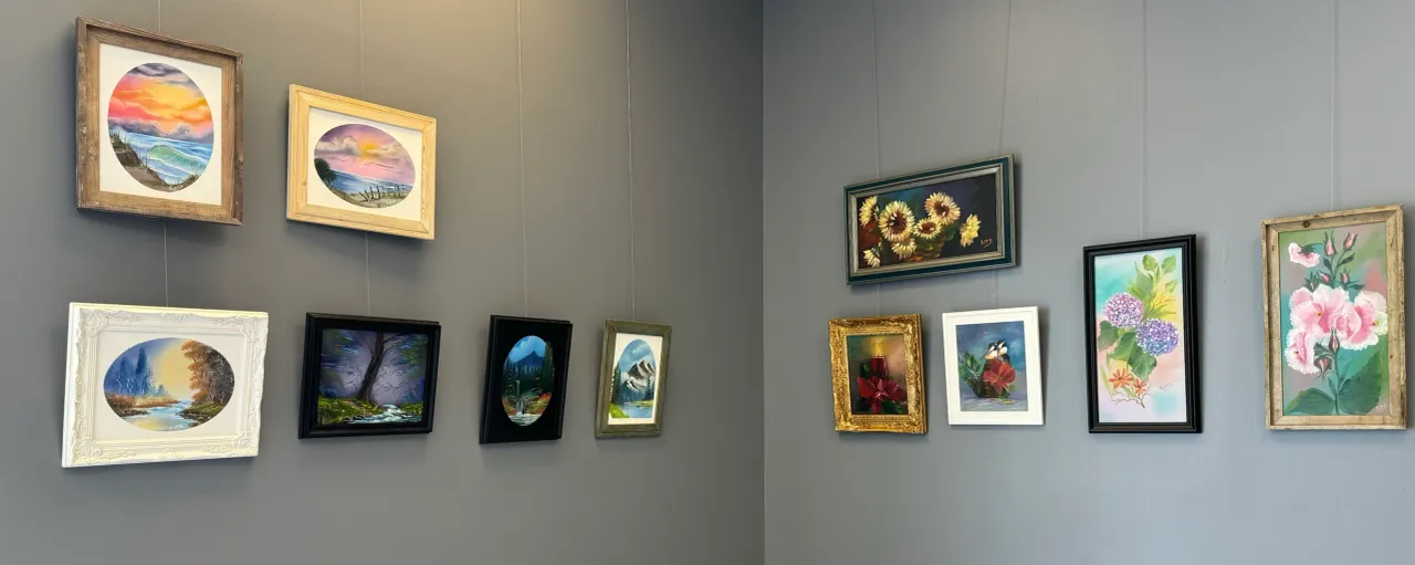 Art gallery wall with framed paintings displayed.