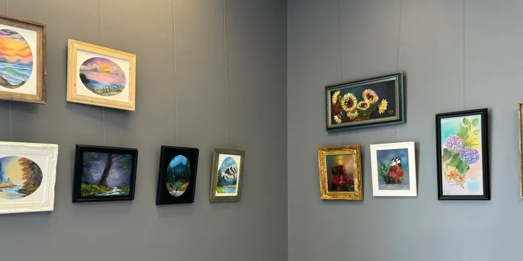 Art gallery wall with framed paintings displayed.