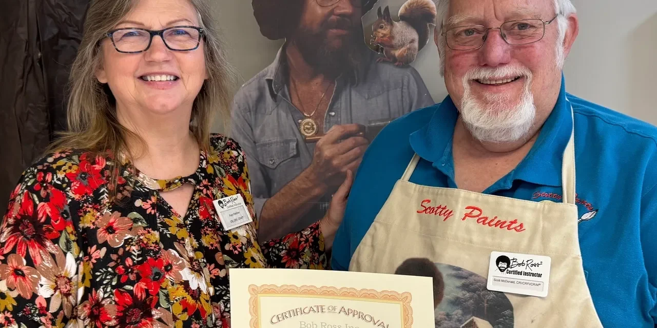 Two people smiling with a certificate.